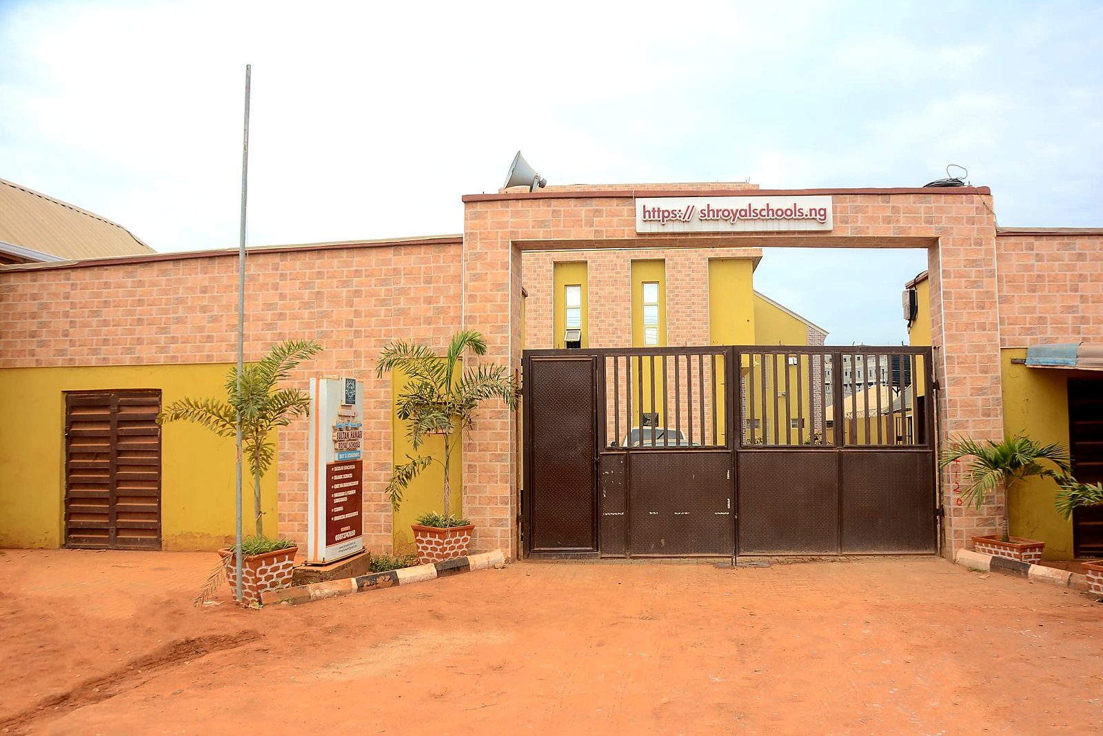 The gate of Sultan Hanafi Royal Schools on Imowonla Road, Ikorodu, carrying the school's name and website