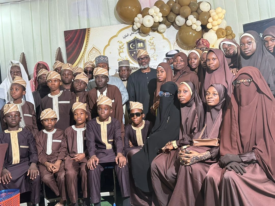 Students of the School of Islamic and Arabic Studies and the Qur'an College at the graduation ceremony, with faculty and visiting scholars behind them