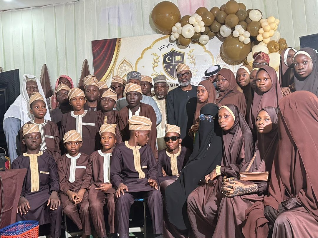 The graduating Hifz cohort of Sultan Hanafi Qur'an College gathered before the school's banner at the graduation ceremony