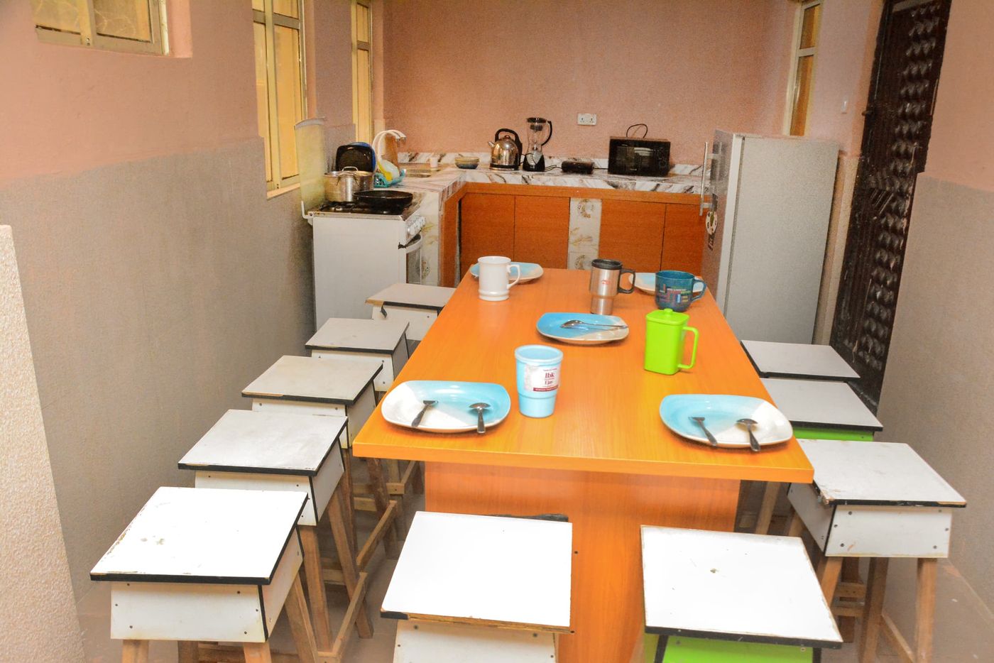 Boarding house kitchen and dining area with a communal table set for meals